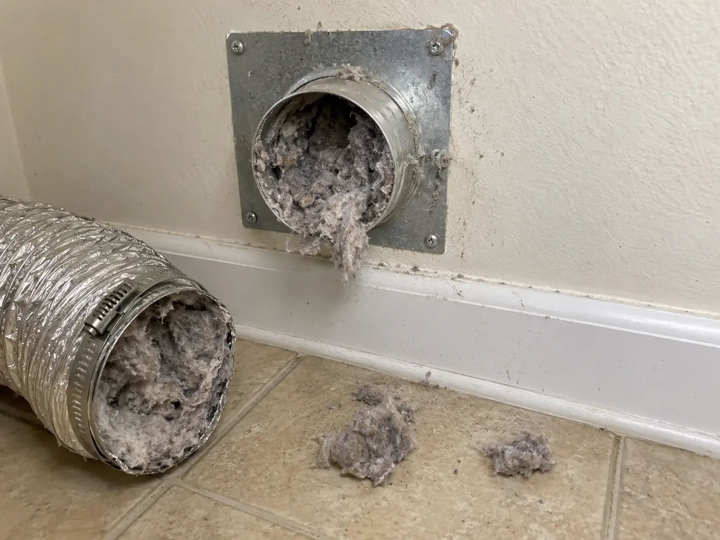 A dryer vent packed with lint before cleaning